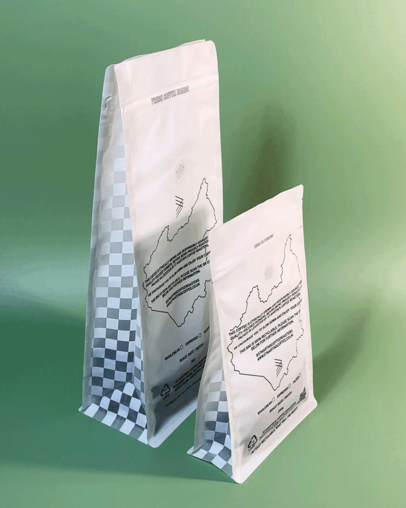 Two coffee bags with checkered bottoms, standing on a green background.