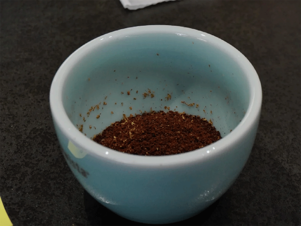 dry coffee grounds in a blue cupping bowl ready for hot water