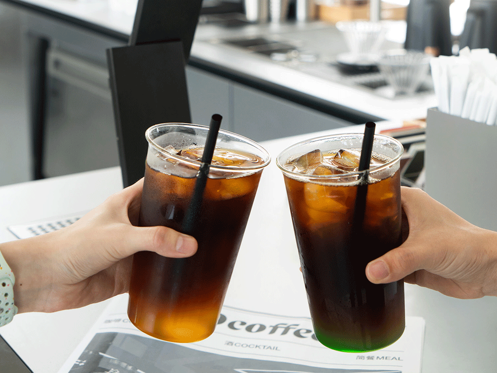 two iced cold brew drinks being served in a cafe