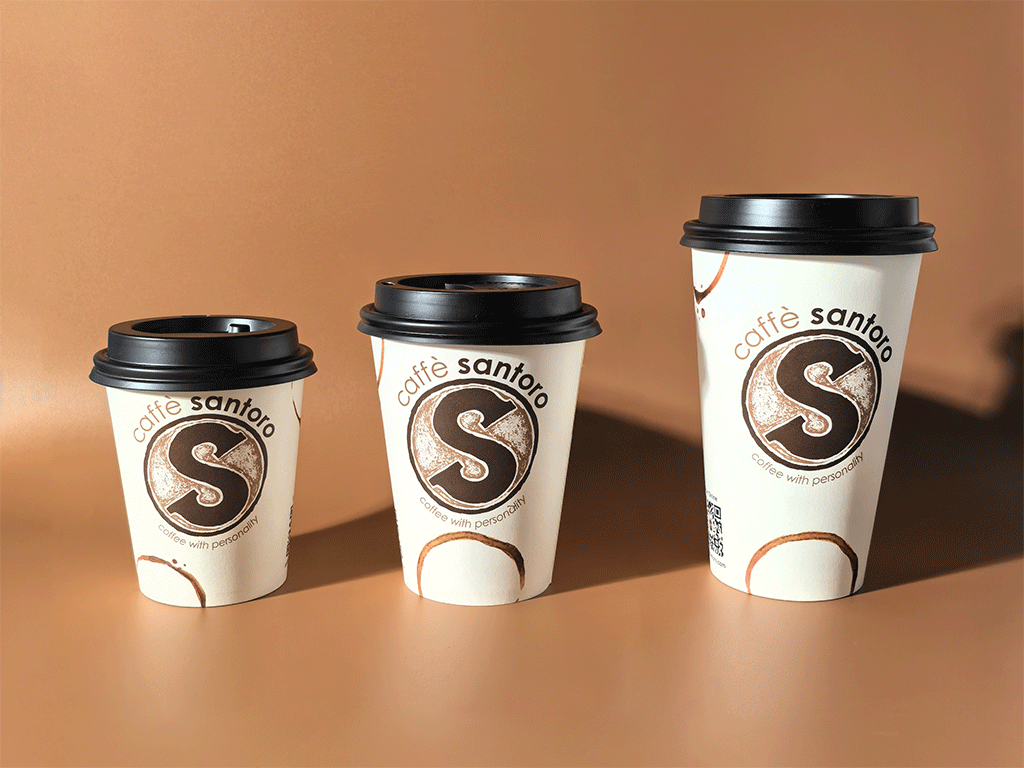 Three disposable coffee cups of different sizes on a surface.
