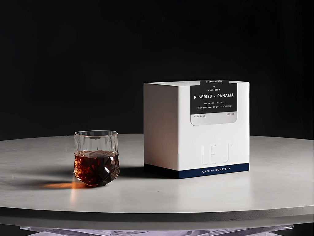 Embossing coffee box with raised logo and minimalist design on a marble table with soft lighting.