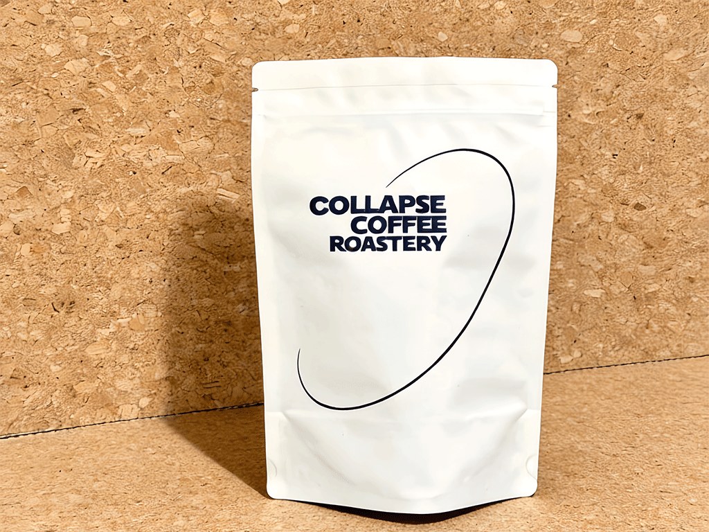 A white coffee bag placed against a cork background.
