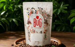 Recycled coffee bag displayed on a wooden tray with coffee beans and natural green background