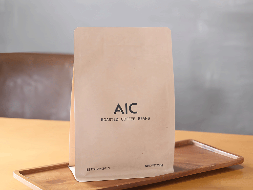 Recycled kraft paper coffee bag displayed on a wooden tray on a tabletop