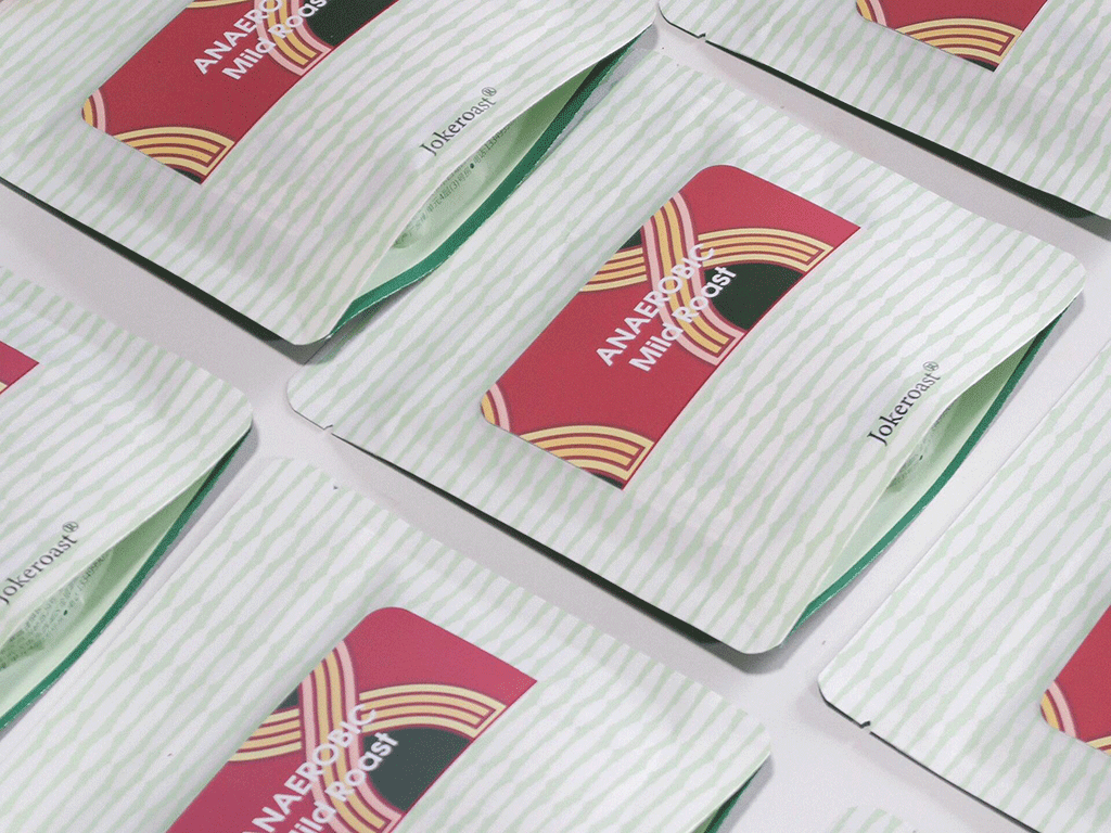 Custom coffee bag labels displayed on multiple coffee pouches in a flat lay arrangement