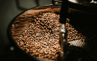 Coffee beans roasting in a machine, illustrating the effect of roast curves on flavor development.
