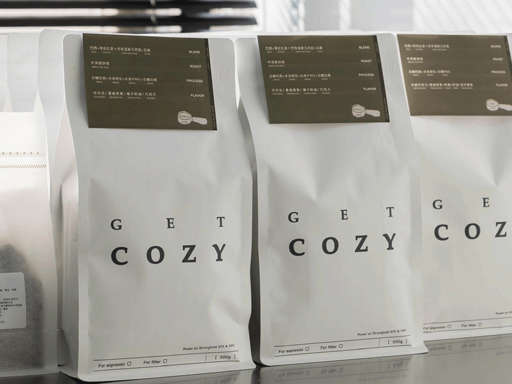 Multiple white flat bottom coffee bags with printed branding and batch information, arranged neatly to illustrate consistent visual identity for small roasters.