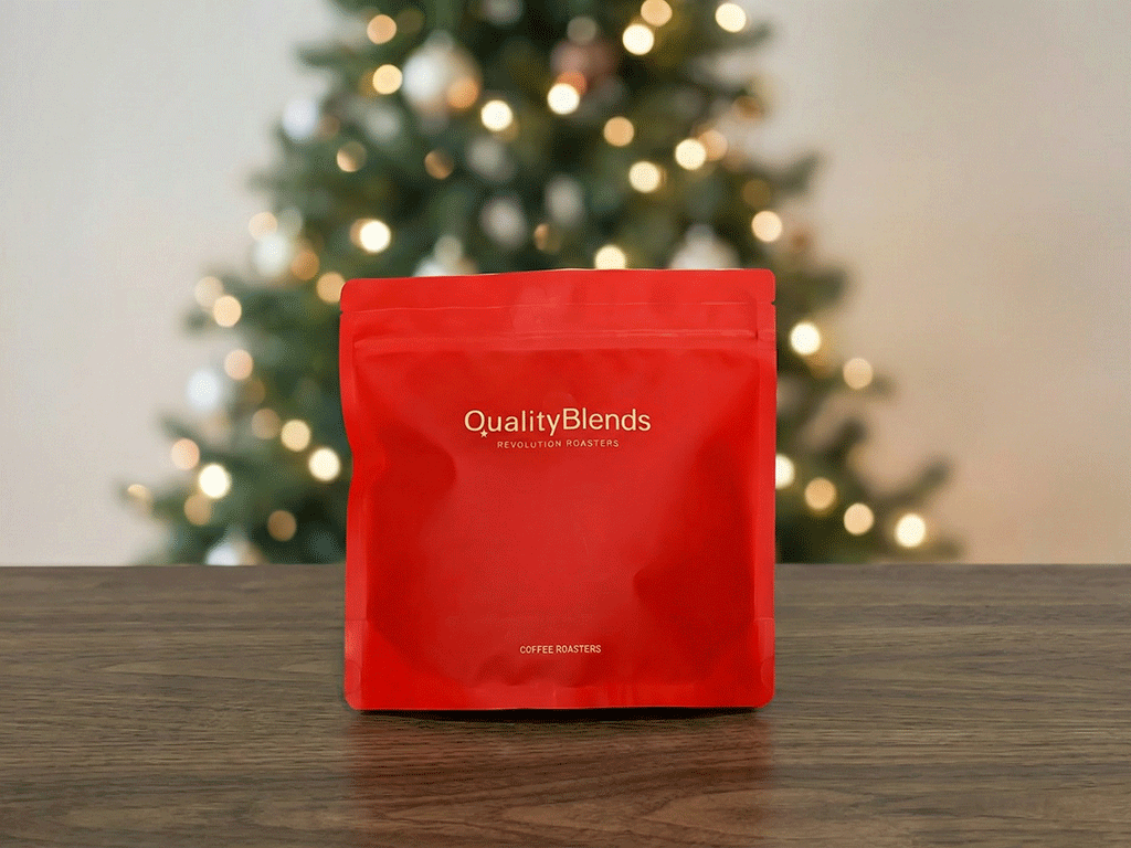 Red coffee bag with a rough matte finish, showcasing a simple logo and text design, set against a blurred background with Christmas lights.