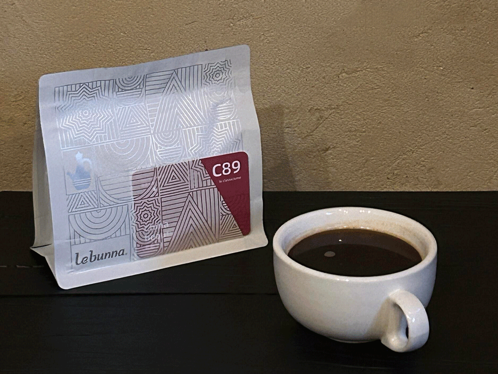 Custom coffee bag displayed next to a cup of brewed coffee