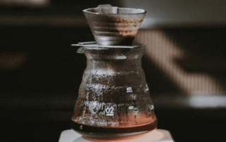 specialty coffee pour over brewing in a glass dripper and server