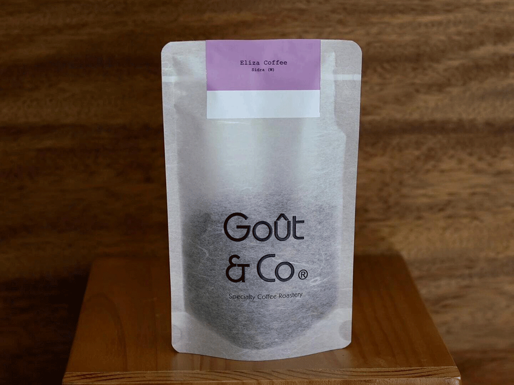 Front view of a gray rice paper coffee pouch with a small colored label on top