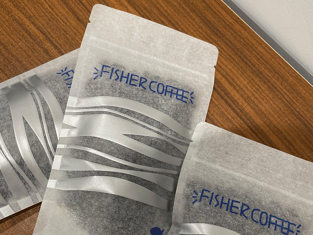 Multiple semi-transparent gray rice paper coffee pouches arranged together, showing printed text and texture