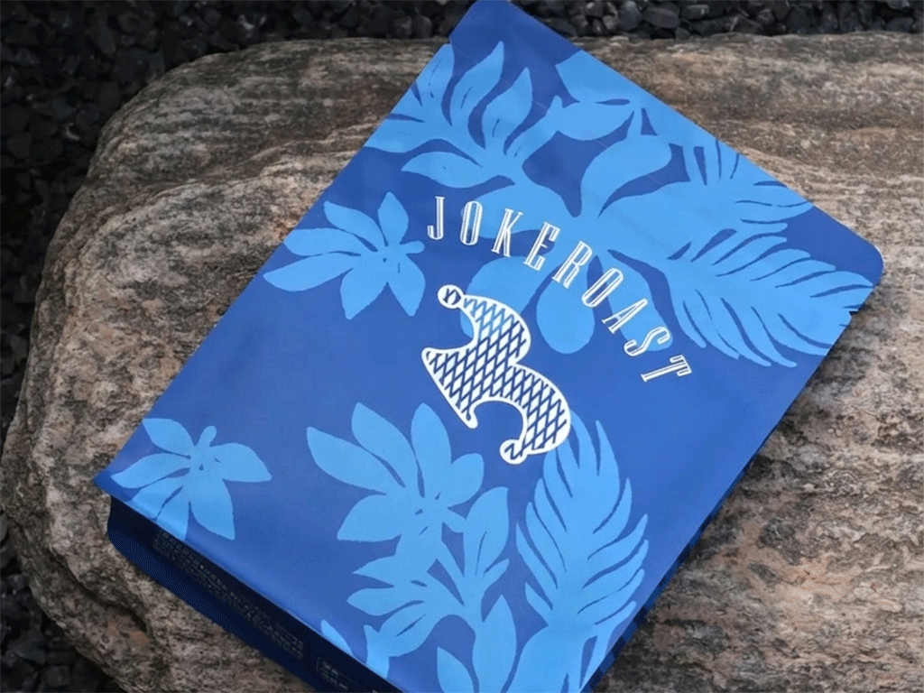 Blue custom coffee box with floral graphics displayed on a stone surface