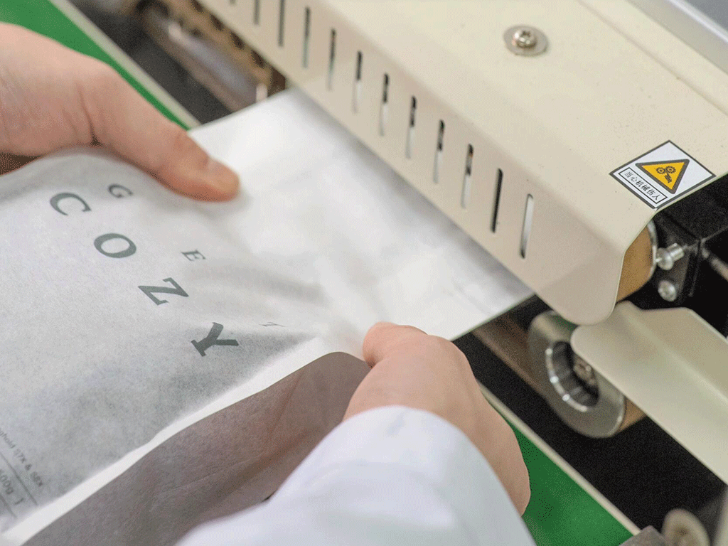 Coffee bag being sealed with a heat sealing machine during the packaging process