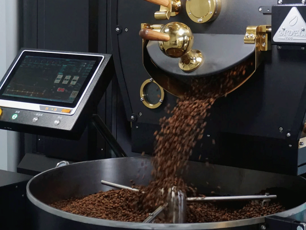 How_to_Accurately_Translate_Roast_Profiles_Between_Roasters_1 Freshly roasted coffee beans being poured from a commercial drum roaster, illustrating the roasting process and Rate of Rise control for coffee roasters