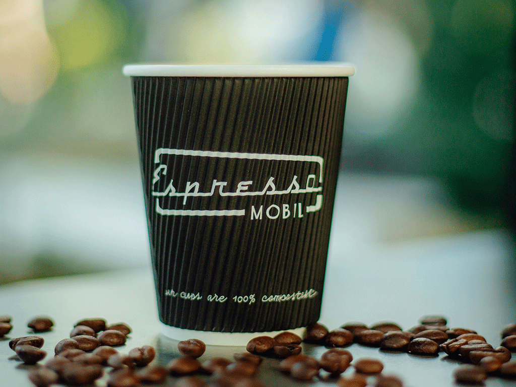 Coffee takeaway cup surrounded by roasted beans for bagasse coffee cup packaging