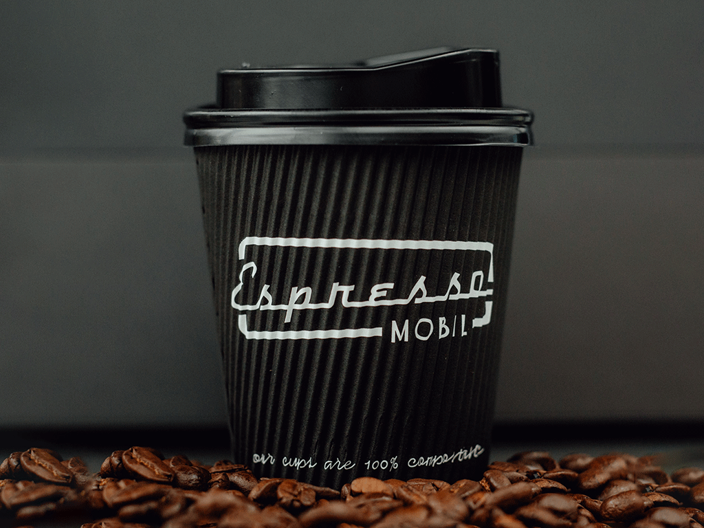 Takeaway coffee cup displayed with roasted beans in a guide to bagasse coffee cups