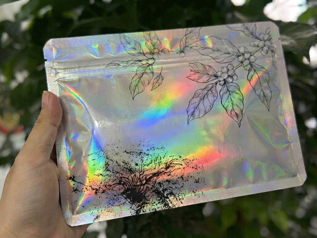 Holographic coffee bag with botanical artwork and iridescent finish