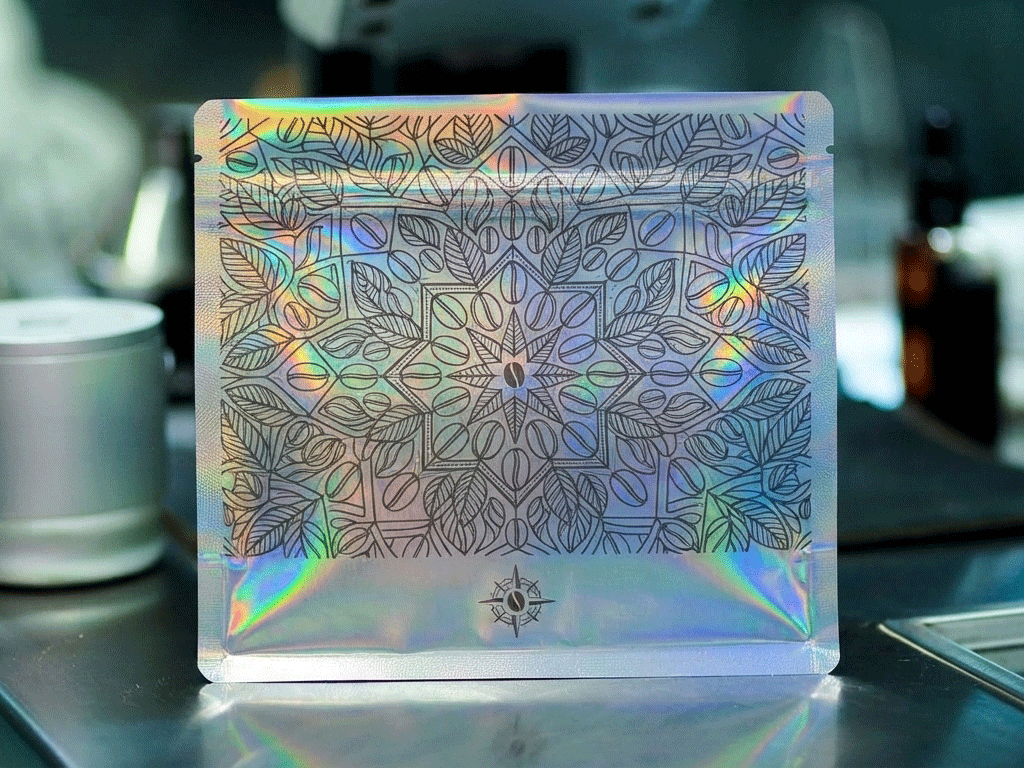 Holographic coffee bag with botanical artwork and iridescent finish
