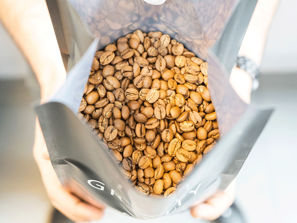 Open view of high-barrier coffee bag manufacturer pouch with degassing valve and beans