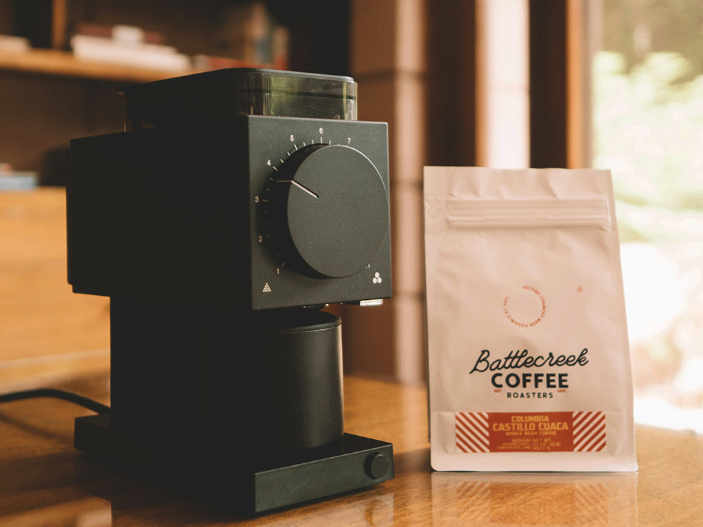 Custom coffee bag beside a grinder showing updated coffee packaging design