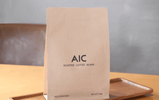 Custom-printed coffee packaging bag with natural paper look displayed on a wooden tray