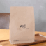 Custom-printed coffee packaging bag with natural paper look displayed on a wooden tray