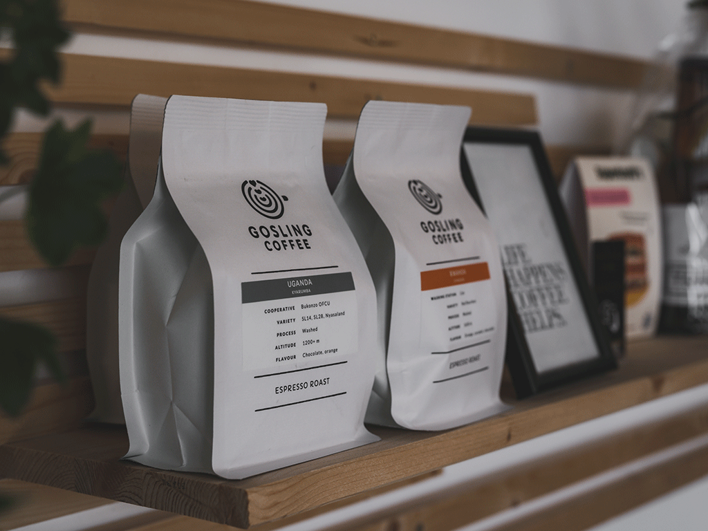 Multiple white coffee bags displayed on a wooden shelf