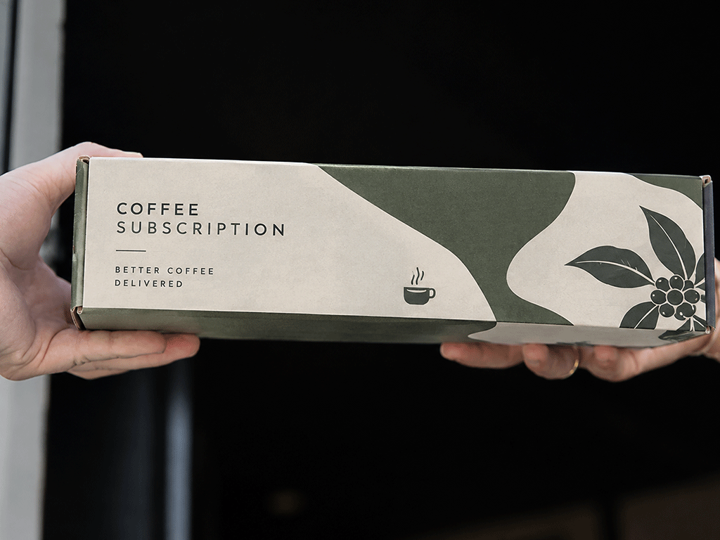 Coffee subscription mailer box being passed between two people