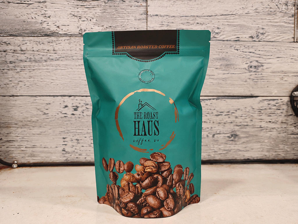 Custom green specialty coffee bag standing on a wooden surface