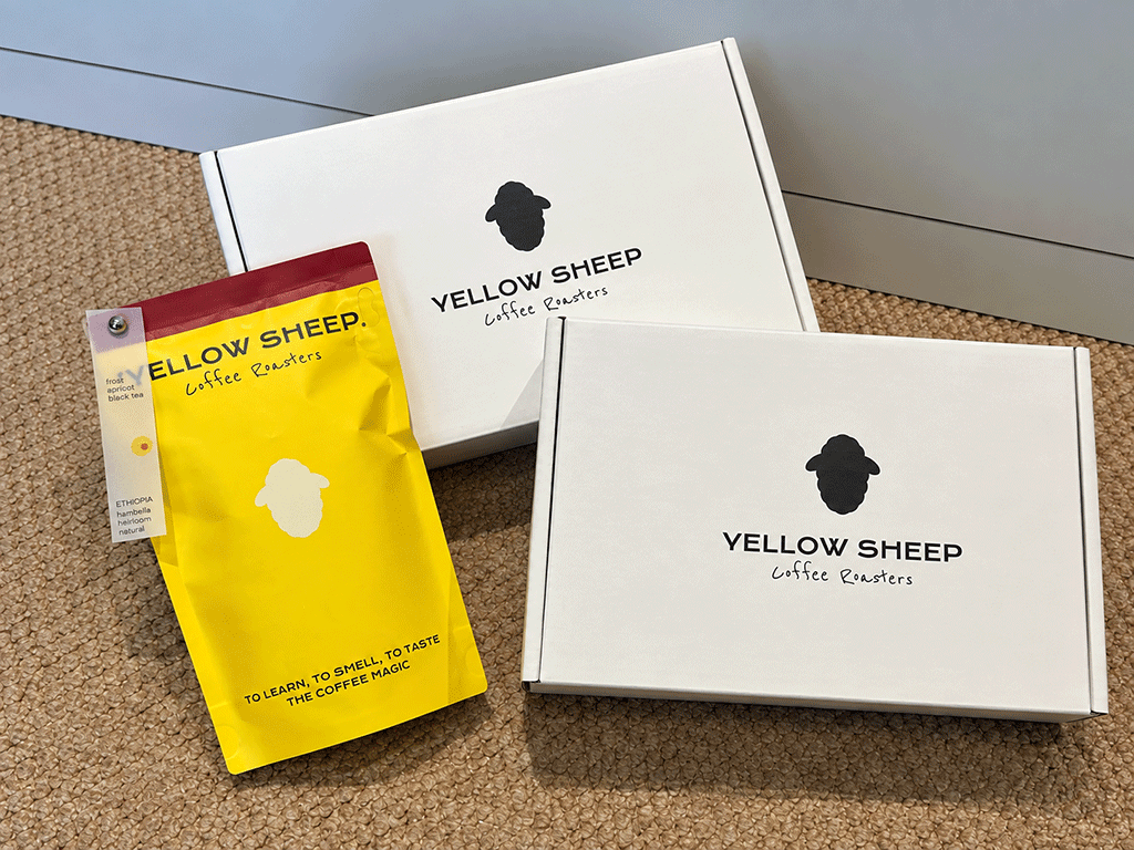 Why_Coffee_Subscription_Churn_Happens_final Yellow coffee bag placed beside two white coffee subscription boxes