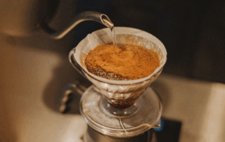 Water poured over coffee grounds during the blooming stage