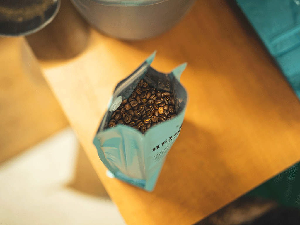 Open coffee bag filled with roasted coffee beans