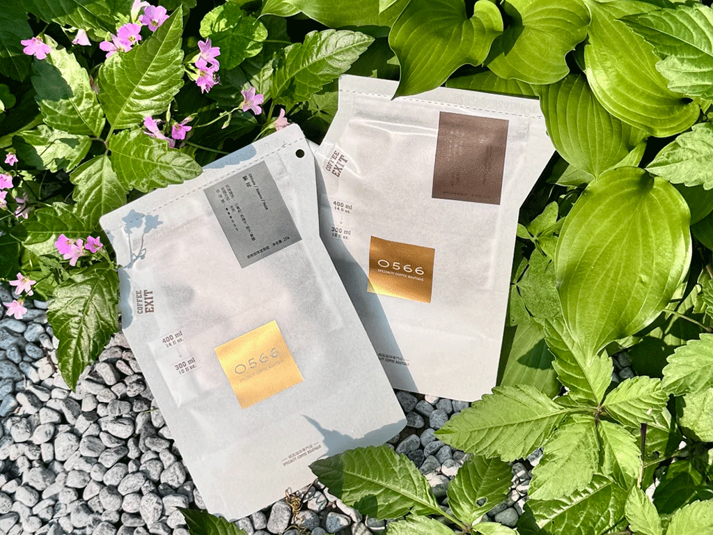 Two custom coffee brewing bags with different label designs placed outdoors