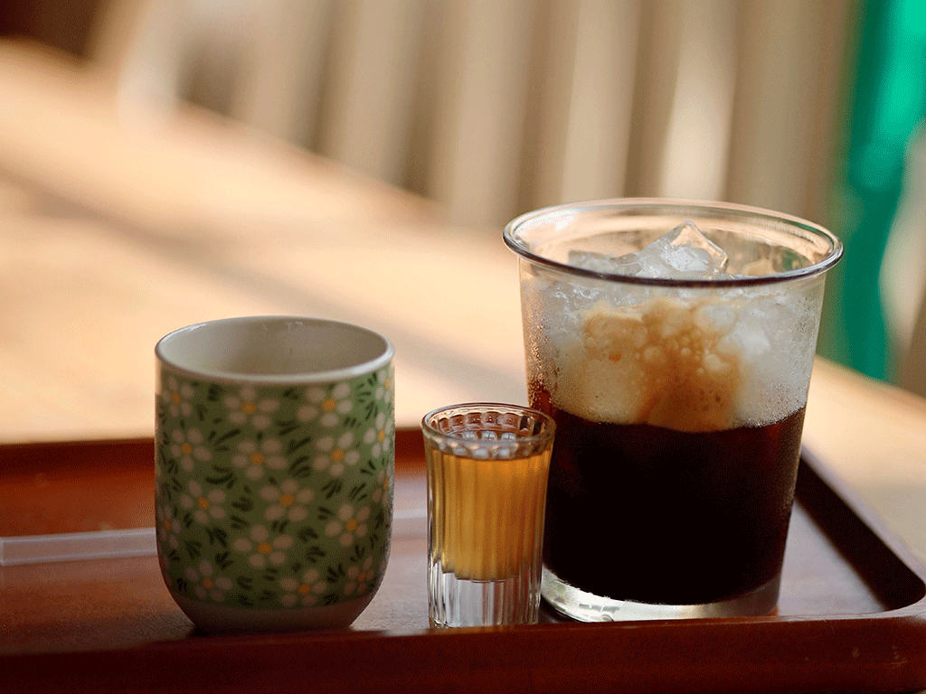 1. Iced coffee and a cup of coffee served on a wooden tray